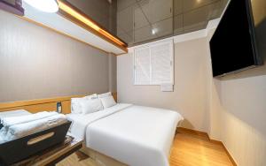 a small room with two beds and a television at Osan No25 Hotel in Osan +18 photos