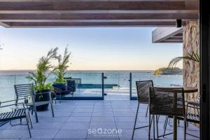 a patio with chairs and a view of the ocean at Studios in a seaside building, close to Beto Carreiro at Penha Spot - PSOB in Gravata