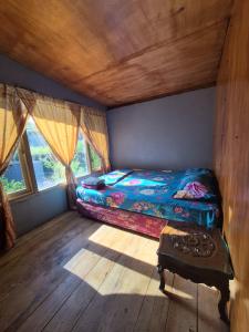 a small bedroom with a bed and a window at Talaga Tomohon Home Stay and Fishing Pond in Tomohon