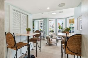 a dining room with tables and chairs and windows at The Marilyn Inn in Ocean Grove