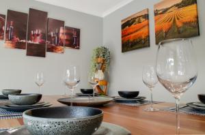 a dining room table with wine glasses on it at Koblenz Haus - “Heart of the Barossa” - (New Mgmt) in Tanunda