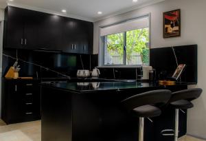 a kitchen with black cabinets and a black counter top at Koblenz Haus - “Heart of the Barossa” - (New Mgmt) in Tanunda