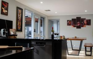a kitchen with a counter and a table with wine glasses at Koblenz Haus - “Heart of the Barossa” - (New Mgmt) in Tanunda