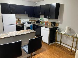 a kitchen with black cabinets and white appliances at Bold property in Calgary