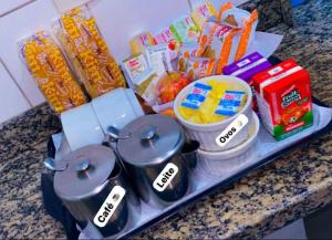 a tray with pots and pans on a counter with food at Namorata Expo Inn in São Paulo
