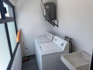 a laundry room with a washing machine and a tv at Orion 2nd Floor in Tepic