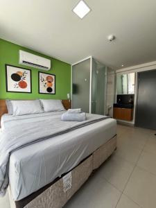 a large bed in a bedroom with green walls at Flat a 20 metros da praia in João Pessoa +40 photos