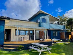 a blue house with a deck and a table at Seaview Lodge in Tairua