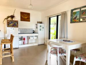 a kitchen with a white table and chairs at Seaview Lodge in Tairua