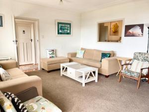a living room with couches and a table at Seaview Lodge in Tairua +37 photos