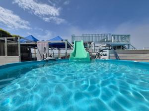 a large swimming pool with a green slide in it at Daebudo Ara Pension in Ansan