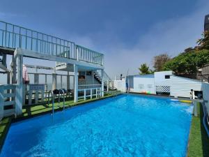 a large blue swimming pool with a building at Daebudo Ara Pension in Ansan