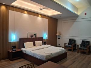 a bedroom with a large bed and a projection screen at Hotel Brindavan Grand in Gulbarga