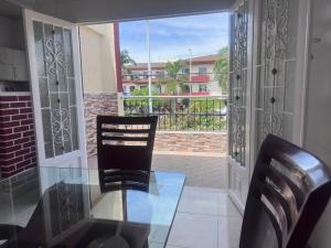a glass table and two chairs on a balcony at Hotel San Luis in Buga
