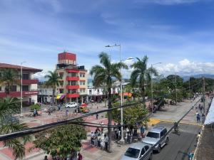 a busy city street with cars and people and buildings at Hotel San Luis in Buga