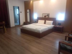 a bedroom with a large bed and a wooden floor at Hotel Brindavan Grand in Gulbarga