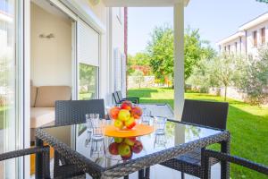 una mesa de cristal con fruta en el porche en Villa Apartments Futura en Vantačići