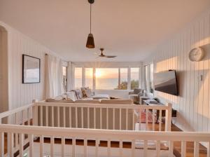 a living room with a crib and a couch at The Pink Door, Absolute Beachfront House in Scarborough