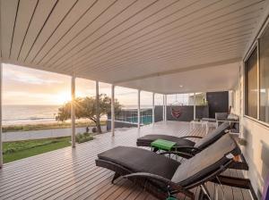 a deck with chairs and a view of the ocean at The Pink Door, Absolute Beachfront House in Scarborough