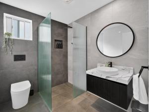 a bathroom with a sink and a mirror at The Pink Door, Absolute Beachfront House in Scarborough +30 photos