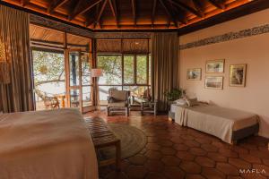 a bedroom with two beds and a living room at Ecohotel Raices del Rosario in Cartagena de Indias