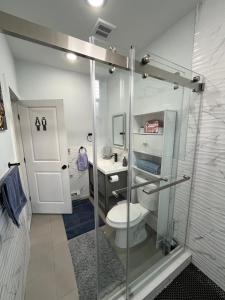 a bathroom with a shower with a toilet and a sink at Modern & Spacious Apartment 15 Min to NYC Near MetLife & American Dream in Jersey City +43 photos