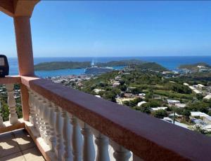 a balcony with a view of a city and the ocean at Cozy House, Ocean View, Saint Thomas in Contant