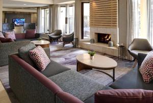 a living room with couches and a fireplace at AmericInn by Wyndham Brookfield in Brookfield