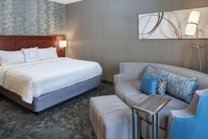 a hotel room with a bed and a couch at AmericInn by Wyndham Brookfield in Brookfield +15 photos
