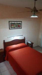 a bedroom with a red bed and a ceiling fan at Hotel El Porteño in Buenos Aires