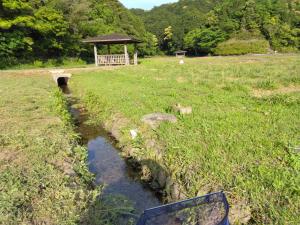 a small stream in a field with a gazebo at Nagata House in Ise
