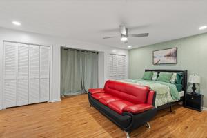 a bedroom with a bed and a red couch at Relaxation spot lawrenceville in Lawrenceville