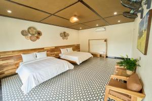 a bedroom with two beds and a mirror at Chài Homestay Sầm Sơn in Sầm Sơn