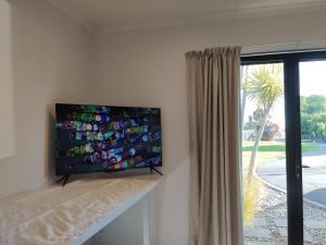 a flat screen tv on a wall next to a window at Tree of Love in Cambridge