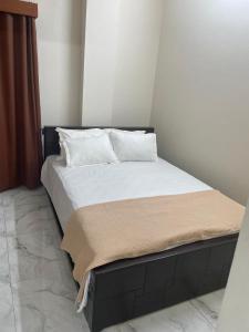 a bed with white sheets and pillows in a room at Best Eastern Suite in Dhaka