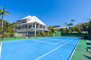 a tennis court in front of a building at Jara - U19 Pandanus Palms Resort in Point Lookout