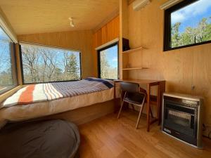 a bedroom with a bed and a desk in a tiny house at awake Gojome in Akita
