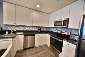 a kitchen with white cabinets and stainless steel appliances at Oceanfront Paradise Sleeps 10 w Stunning Sunrises in Myrtle Beach
