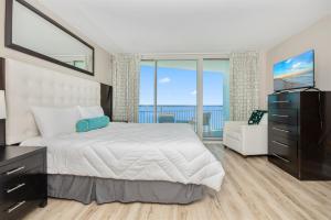 a bedroom with a bed and a large window at Oceanfront Paradise Sleeps 10 w Stunning Sunrises in Myrtle Beach