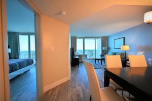 a hotel room with a bed and a dining room at Oceanfront Paradise Sleeps 10 w Stunning Sunrises in Myrtle Beach