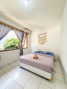 a bedroom with a bed with a teddy bear on it at OsteL By OstiC in Bandung