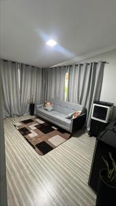 a living room with a couch in a room at Recanto Guarujá Moc in Montes Claros +4 photos