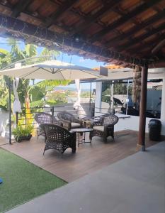 a patio with chairs and a table and an umbrella at Recanto Guarujá Moc in Montes Claros