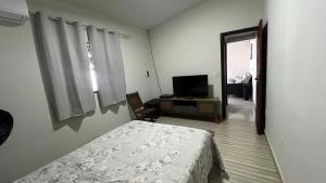 a bedroom with a bed and a tv in it at Recanto Guarujá Moc in Montes Claros