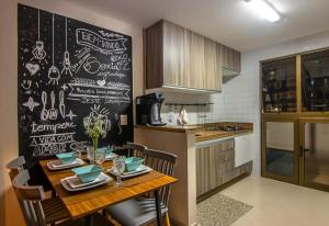 a kitchen with a table and a chalkboard wall at Refúgio do poeta in Natal
