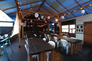 a restaurant with wooden tables and chairs and lights at Glamping Village LEAF in Mashiki