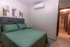 a bedroom with a bed with a green comforter at Refúgio do poeta in Natal +25 photos