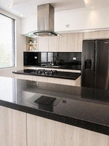 a kitchen with a black counter top and a refrigerator at Espectacular Casa Quinta in Girardot