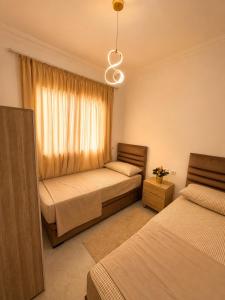 a bedroom with two beds and a window at Modern Comfort Stay Tanger in Tangier