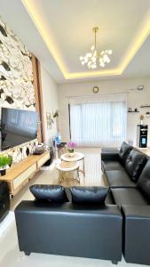 a living room with a couch and a table at Villa Adela Sky Land Malang in Karangploso